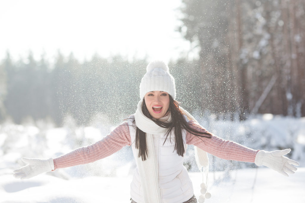 Cheerful young woman in winter time outdoors having fun